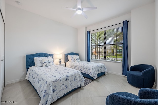 tiled bedroom featuring baseboards and ceiling fan