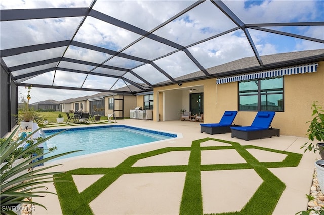 outdoor pool featuring glass enclosure and a patio