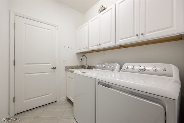 clothes washing area featuring light tile patterned flooring, independent washer and dryer, cabinet space, and a sink