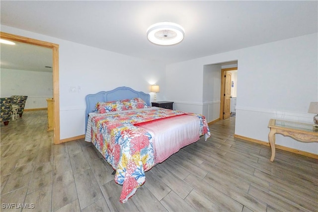 bedroom with baseboards and wood finished floors