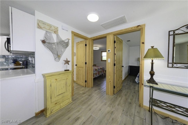 hall with light wood-type flooring and visible vents