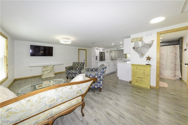 living area featuring light wood-style floors and baseboards