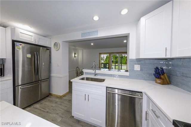 kitchen featuring stainless steel appliances, dark wood-style flooring, a sink, and white cabinets