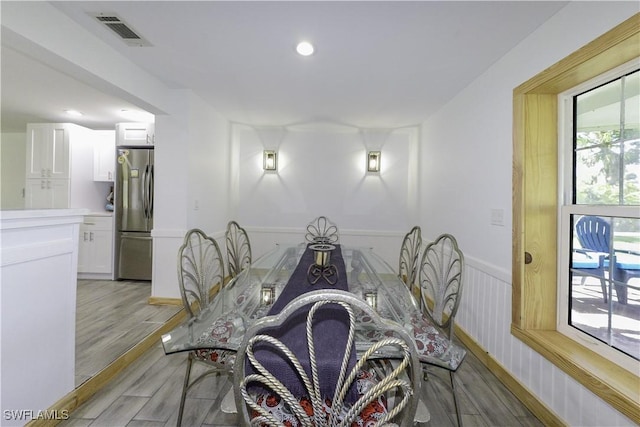 dining room featuring light wood-style floors, recessed lighting, visible vents, and wainscoting