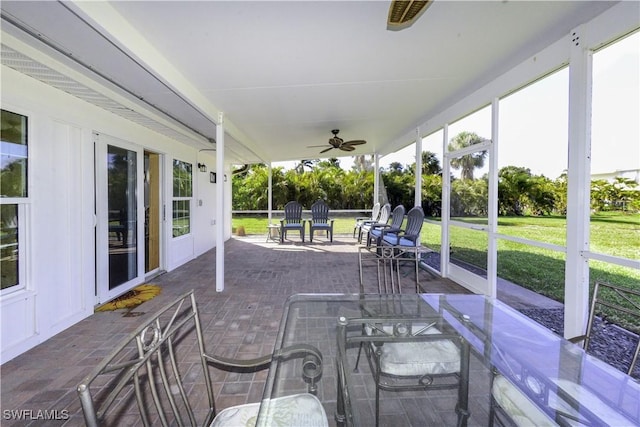 unfurnished sunroom featuring a ceiling fan