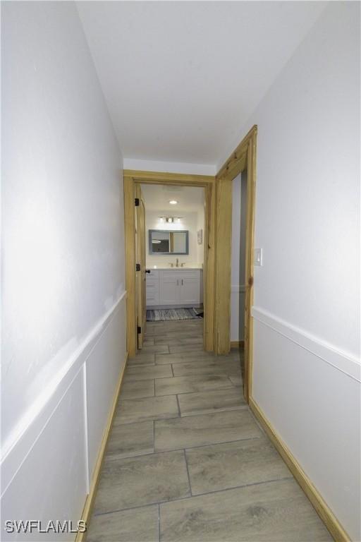 hall with a wainscoted wall and a sink