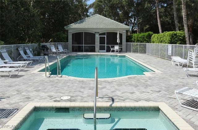 community pool featuring a sunroom, a hot tub, fence, and a patio