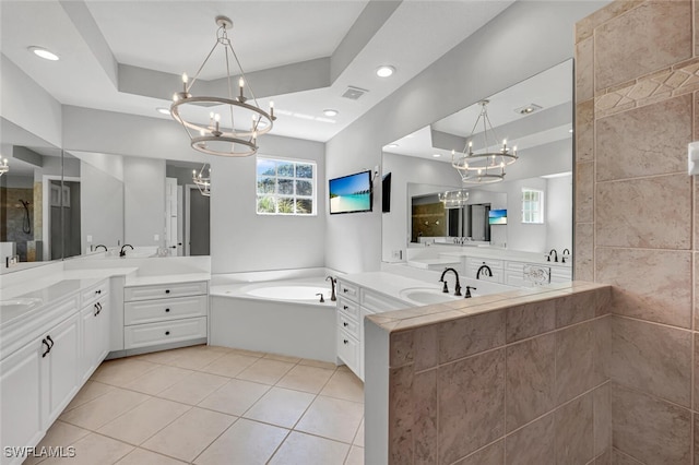 full bath featuring an inviting chandelier, visible vents, a raised ceiling, and two vanities