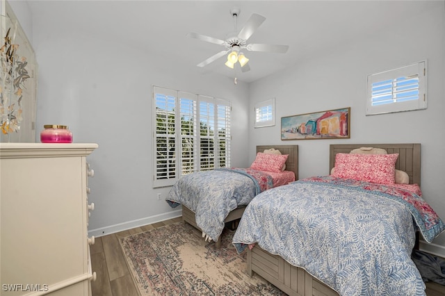 bedroom featuring ceiling fan, baseboards, and wood finished floors