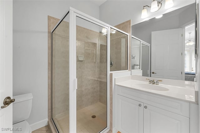 bathroom featuring toilet, a stall shower, and vanity