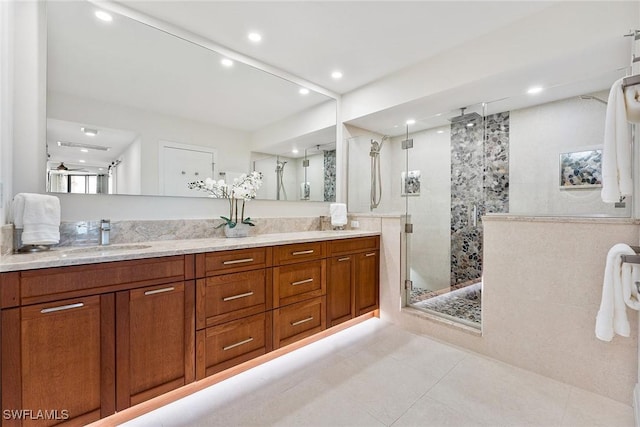 bathroom featuring double vanity, a stall shower, tile patterned flooring, a sink, and recessed lighting