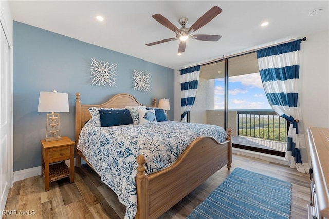 bedroom with baseboards, ceiling fan, wood finished floors, access to exterior, and floor to ceiling windows