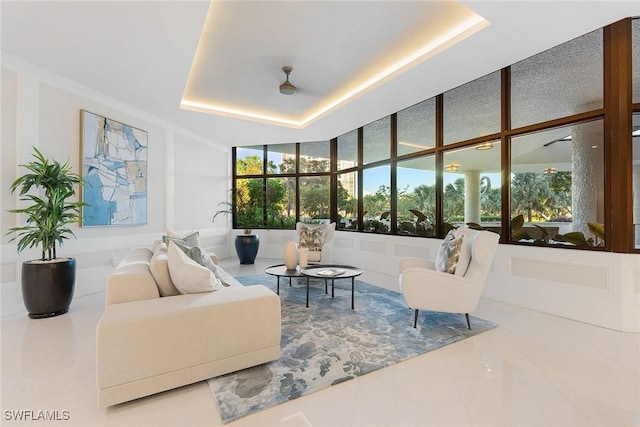 living room featuring a tray ceiling and tile patterned floors