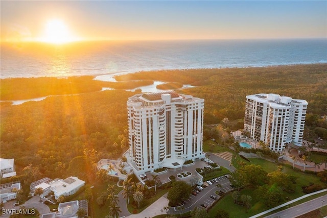 aerial view at dusk featuring a water view and a view of city