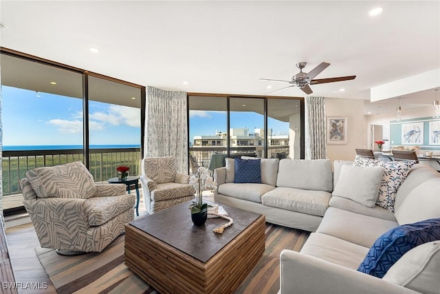 living room featuring a ceiling fan, recessed lighting, floor to ceiling windows, and wood finished floors