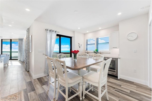 dining area with baseboards, a healthy amount of sunlight, and light wood finished floors