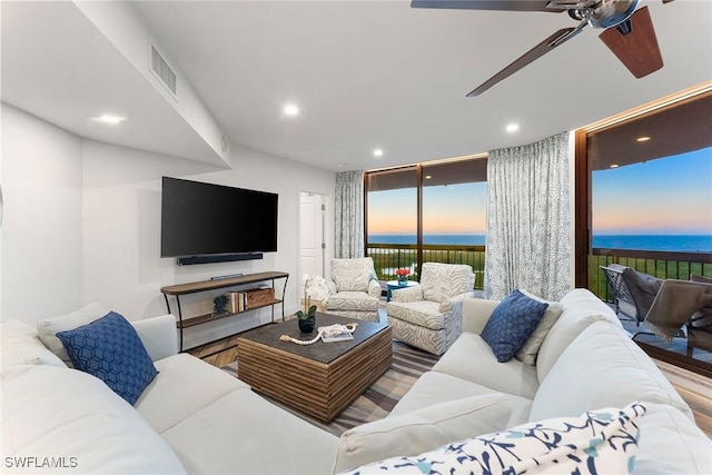 living room with a wall of windows, recessed lighting, visible vents, and wood finished floors