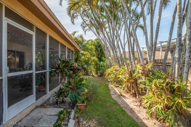 view of yard with a sunroom and fence