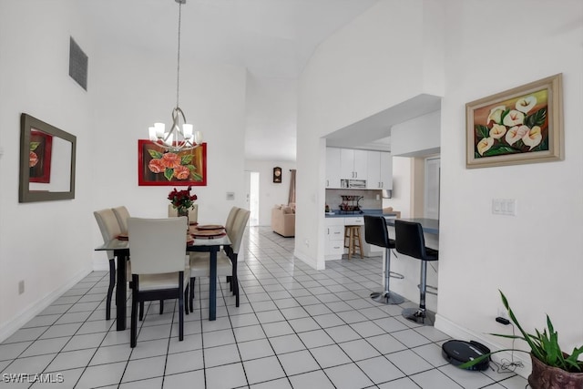 dining area featuring a towering ceiling, visible vents, a notable chandelier, and light tile patterned flooring