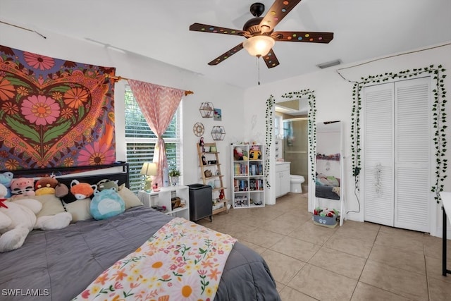 bedroom featuring ceiling fan, ensuite bathroom, and light tile patterned floors