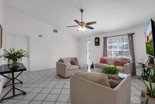 living area with light tile patterned floors, visible vents, a ceiling fan, vaulted ceiling, and baseboards