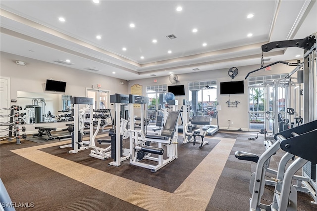 gym featuring visible vents, recessed lighting, a tray ceiling, and baseboards