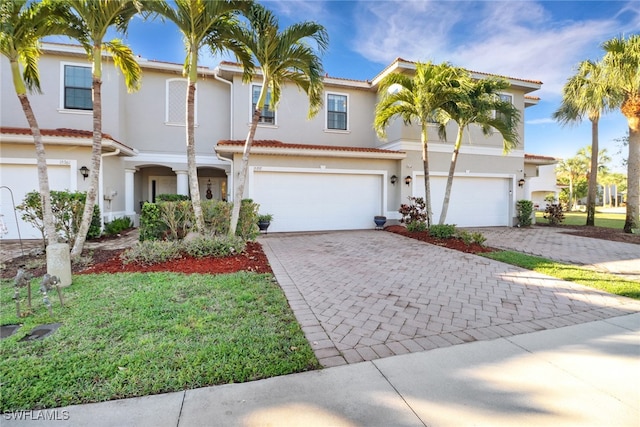 view of front of home featuring a garage, stucco siding, and decorative driveway