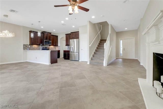 kitchen with tasteful backsplash, light tile patterned floors, appliances with stainless steel finishes, a ceiling fan, and open floor plan