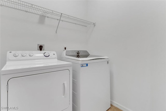 laundry room with baseboards, washer and dryer, and laundry area