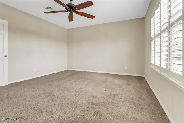 unfurnished room with a ceiling fan, visible vents, carpet, and baseboards