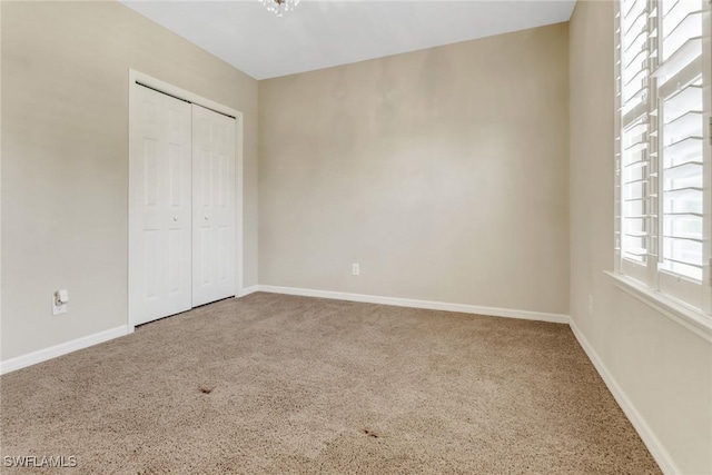 unfurnished bedroom with baseboards, a closet, and carpet