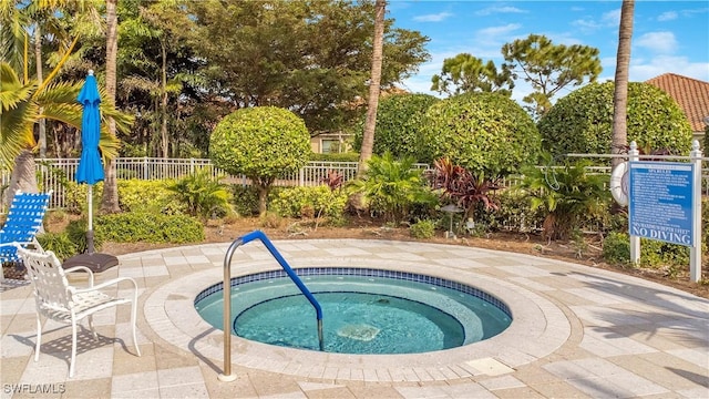 view of swimming pool featuring a community hot tub and fence