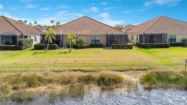 back of house featuring a water view, glass enclosure, a tiled roof, and a yard