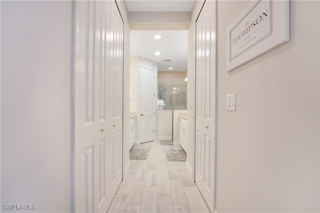 hallway with recessed lighting, visible vents, light wood-style flooring, and baseboards