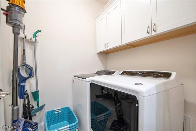 clothes washing area with cabinet space and washer and clothes dryer