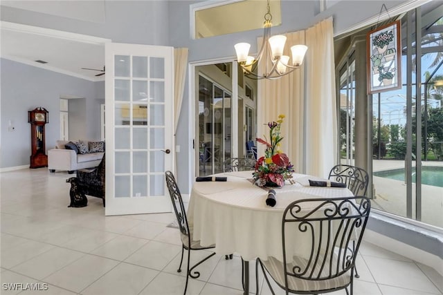 tiled dining space featuring crown molding, baseboards, and ceiling fan with notable chandelier