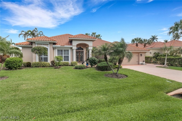 mediterranean / spanish house featuring an attached garage, driveway, a front yard, and a tile roof