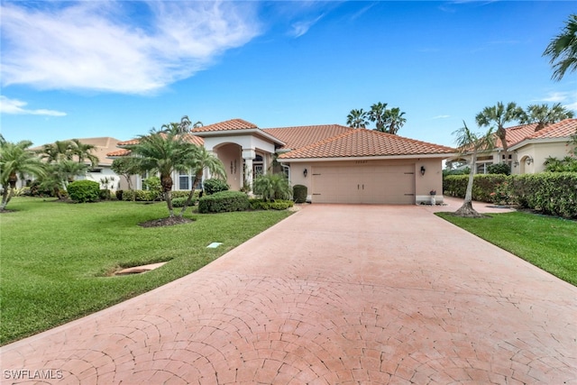 mediterranean / spanish home with concrete driveway, a tile roof, a front lawn, and stucco siding