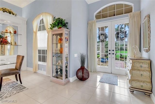 doorway with light tile patterned floors, baseboards, and french doors