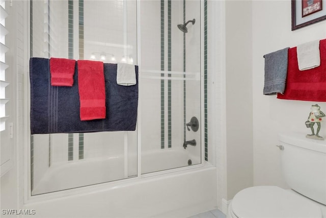 full bathroom featuring toilet and bath / shower combo with glass door