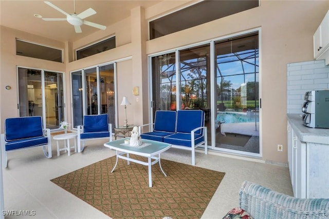 view of patio / terrace featuring ceiling fan and glass enclosure