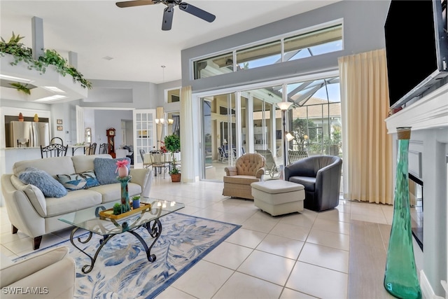 living area with light tile patterned floors and ceiling fan with notable chandelier