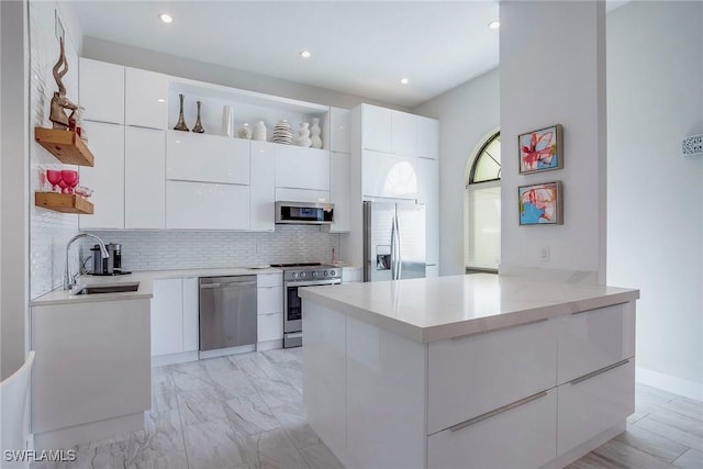 kitchen with tasteful backsplash, modern cabinets, stainless steel appliances, and a sink