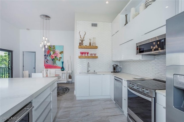 kitchen featuring visible vents, modern cabinets, appliances with stainless steel finishes, light countertops, and a sink