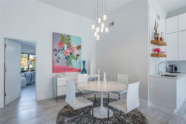 dining space featuring light wood finished floors, visible vents, and baseboards