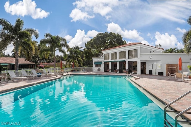 pool with a patio area and fence