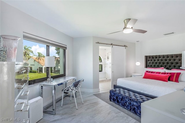 bedroom with visible vents, ensuite bathroom, a ceiling fan, a barn door, and baseboards