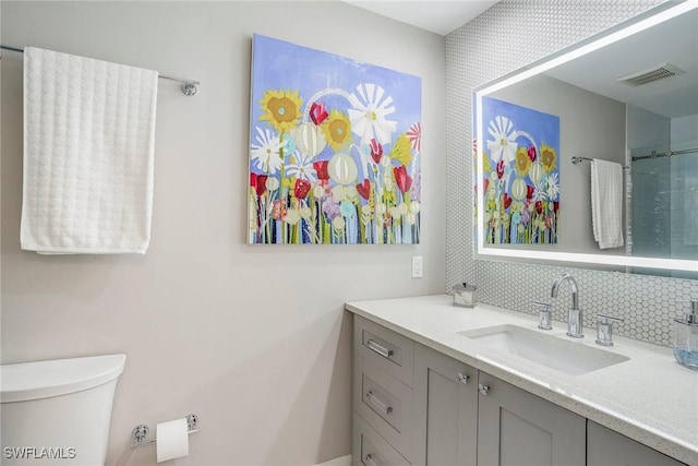 full bathroom with toilet, tasteful backsplash, visible vents, and vanity