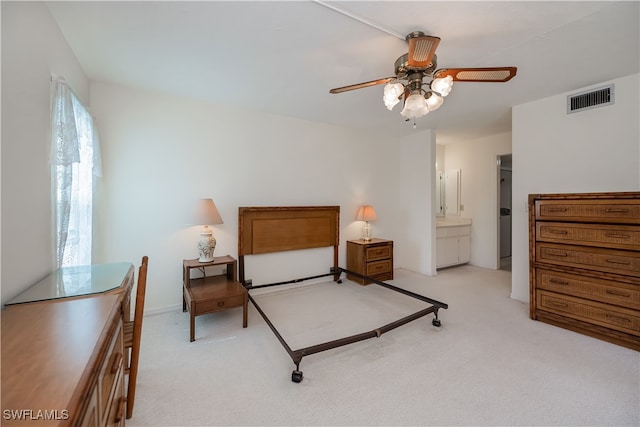 bedroom featuring light carpet, ceiling fan, visible vents, and ensuite bathroom