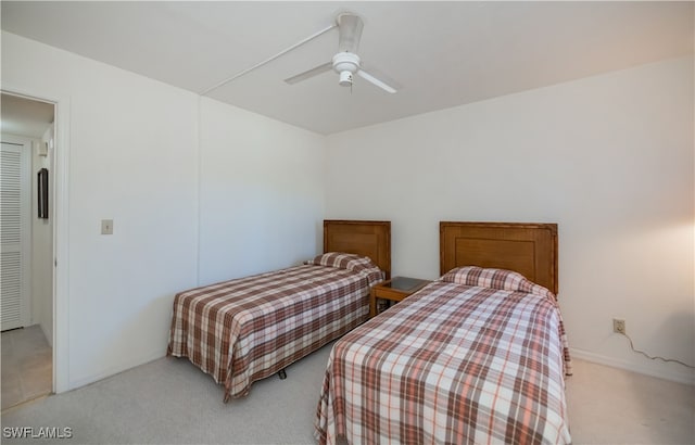 bedroom with a ceiling fan and light colored carpet